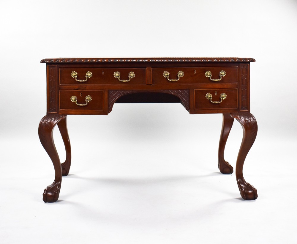 A dark brown mahogany Chippendale style writing table featuring cabriole legs with claw and ball feet, carved knees, gadrooned edging, and drawers with brass swan-neck handles. View II