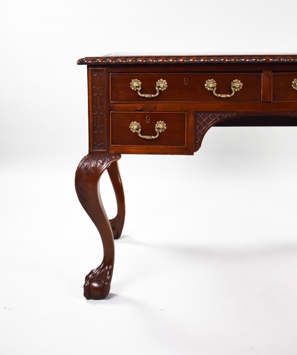 A dark brown mahogany Chippendale style writing table featuring cabriole legs with claw and ball feet, carved knees, gadrooned edging, and drawers with brass swan-neck handles. View III