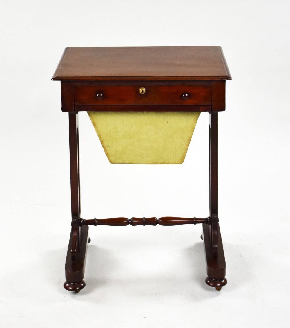 A Victorian mahogany work table featuring a single drawer with wooden knobs, a suspended yellow patterned fabric basket below, and a turned stretcher base set on castors. View II