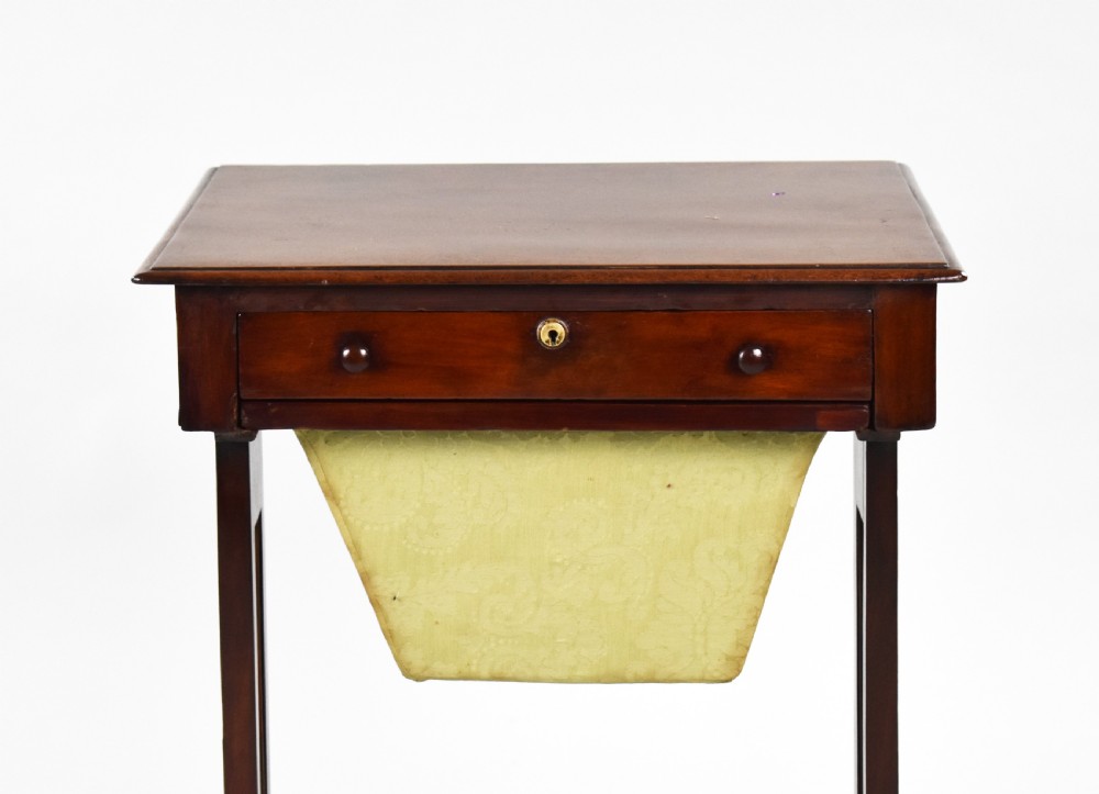 A Victorian mahogany work table featuring a single drawer with wooden knobs, a suspended yellow patterned fabric basket below, and a turned stretcher base set on castors. View III