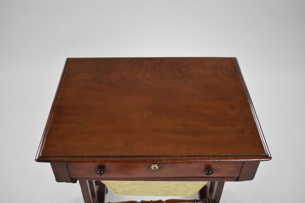 A Victorian mahogany work table featuring a single drawer with wooden knobs, a suspended yellow patterned fabric basket below, and a turned stretcher base set on castors. View V