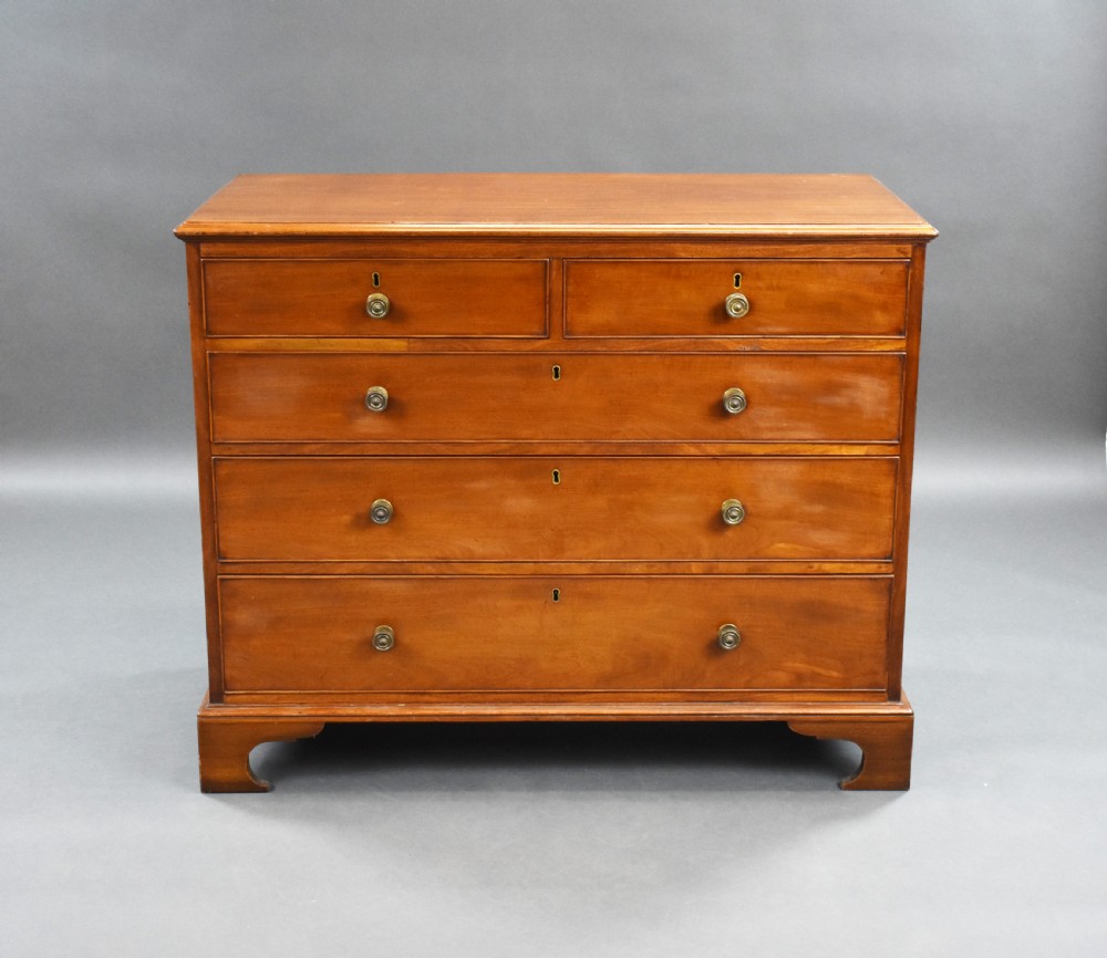 A George III mahogany chest of drawers featuring two short over three long graduated drawers resting on classic bracket feet. View II