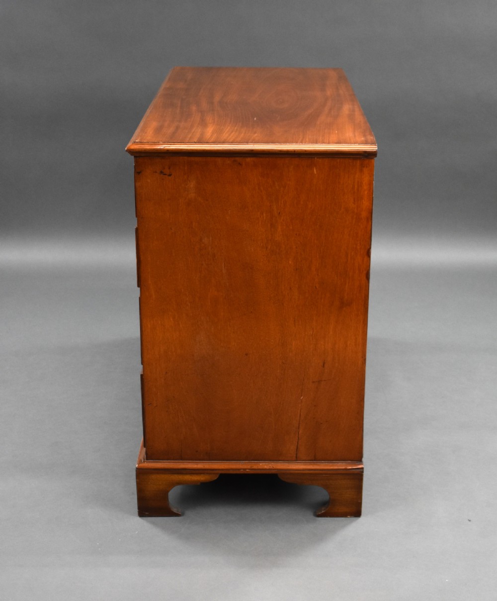 A George III mahogany chest of drawers featuring two short over three long graduated drawers resting on classic bracket feet. View V