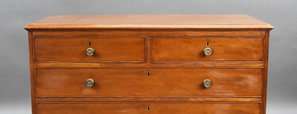 A George III mahogany chest of drawers featuring two short over three long graduated drawers resting on classic bracket feet. View VI
