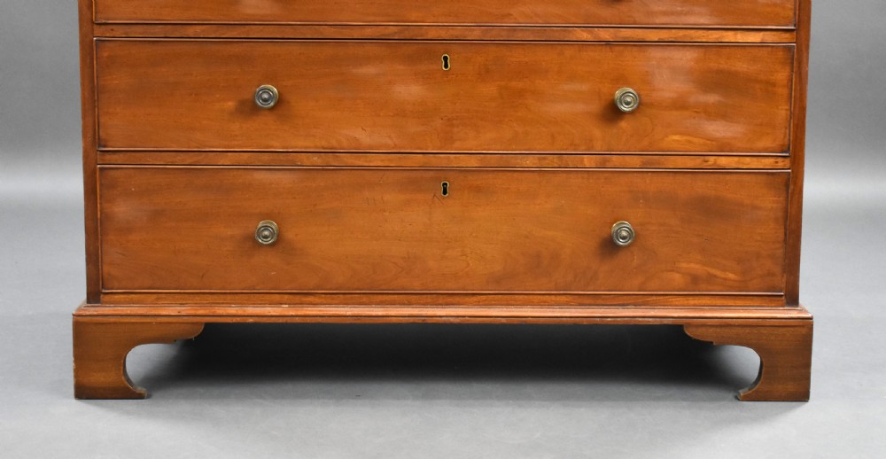 A George III mahogany chest of drawers featuring two short over three long graduated drawers resting on classic bracket feet. View VII