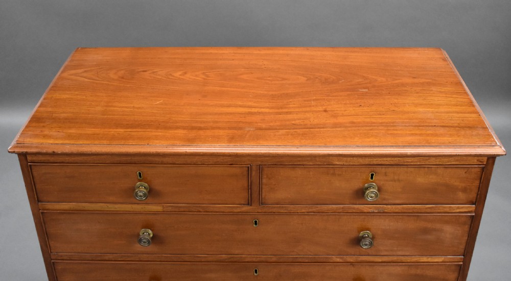 A George III mahogany chest of drawers featuring two short over three long graduated drawers resting on classic bracket feet. View VIII