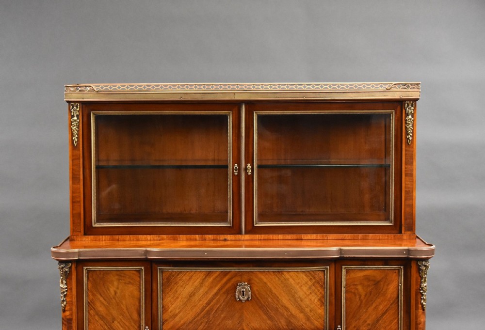 A 19th-century French walnut cabinet featuring a two-door glazed top display section above a lower storage unit with drawers and brass mounts, raised on tapered legs. View III