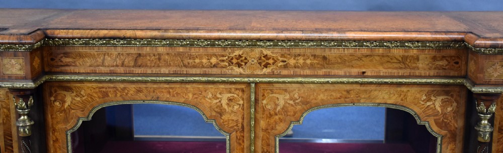 Victorian burr walnut credenza featuring floral marquetry inlays, glazed central double doors, curved glass side display sections, and gilt-bronze column mounts. View XIV