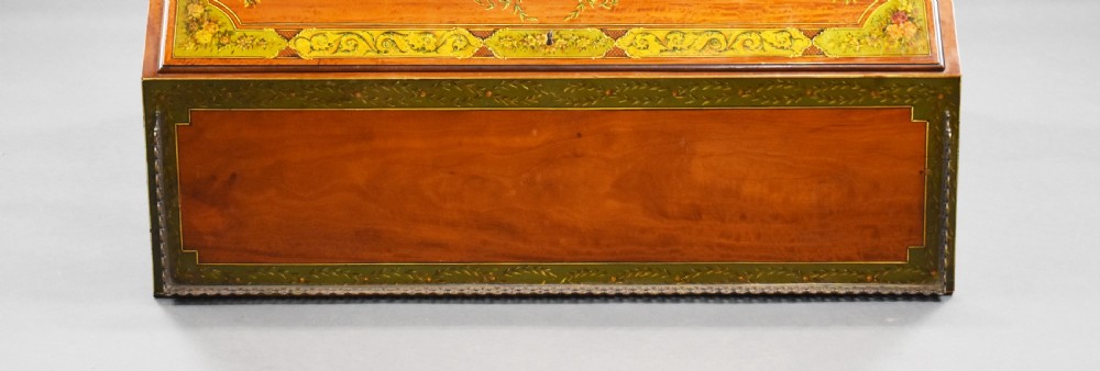 An Edwardian hand-painted satinwood bureau featuring a slant front with a classical central medallion and floral swags above four graduated drawers. View XX