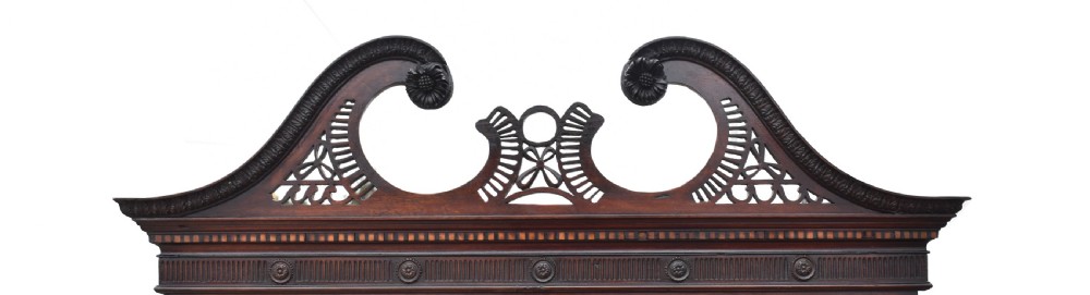 A George III mahogany secretaire bookcase featuring a carved swan-neck pediment, glazed astragal doors, and a chest base with turned handles. View VI
