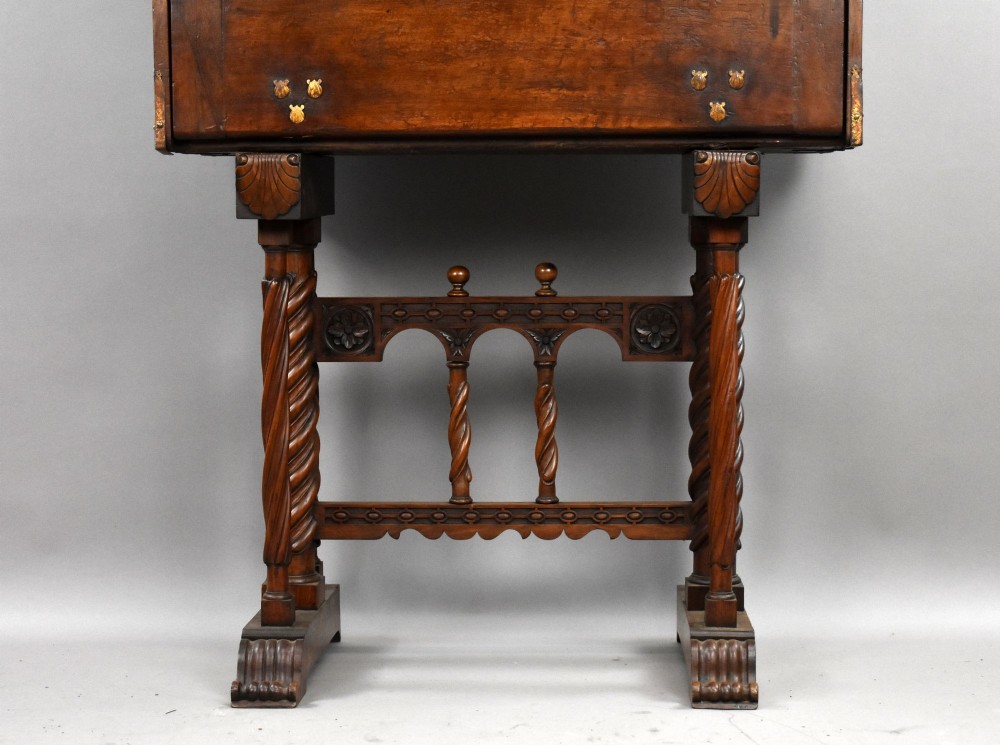 A 17th-century Spanish walnut Bargueno cabinet featuring an intricate brass lockplate and side mounts, resting on an ornate barley-twist wooden stand. View VI
