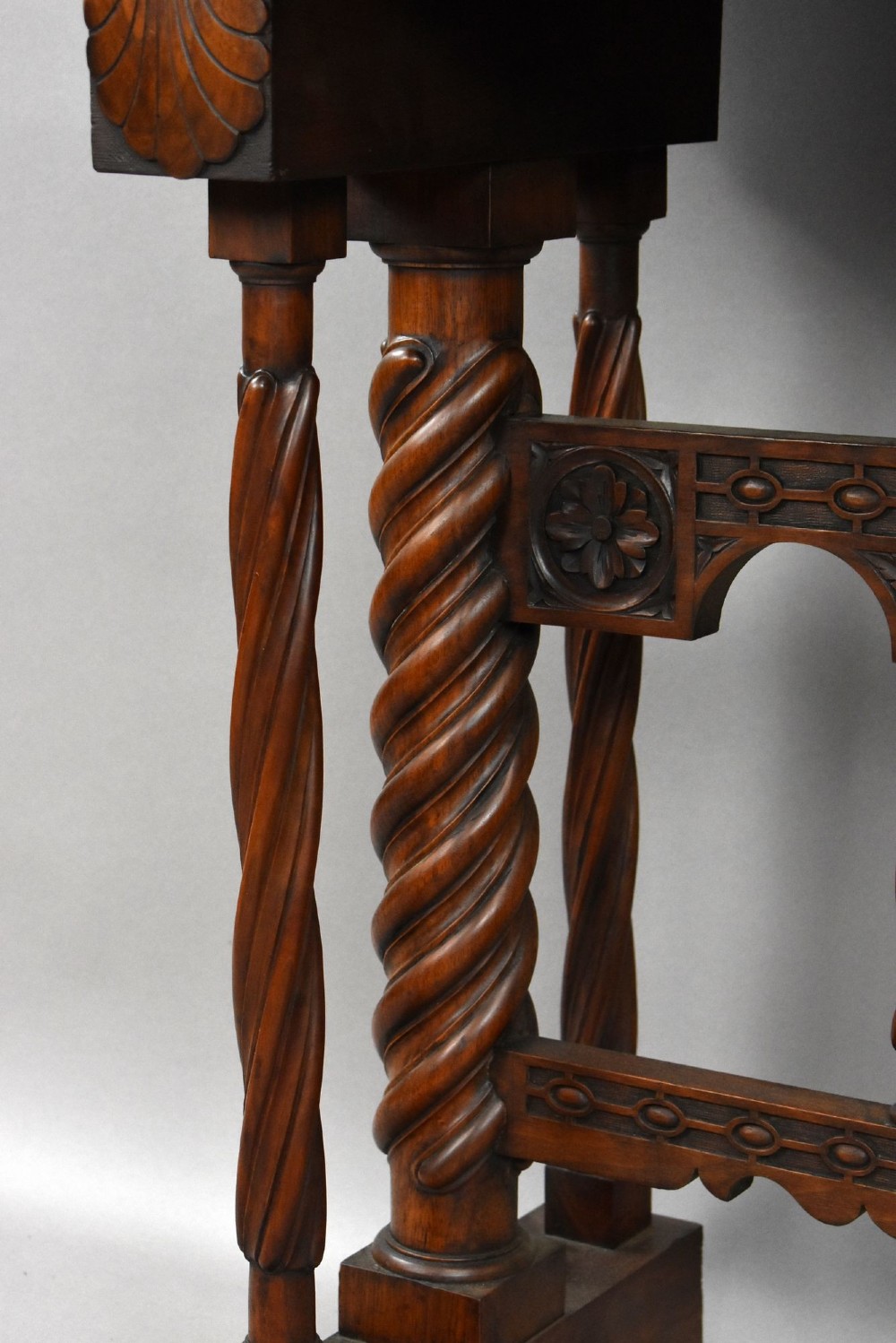 A 17th-century Spanish walnut Bargueno cabinet featuring an intricate brass lockplate and side mounts, resting on an ornate barley-twist wooden stand. View VIII