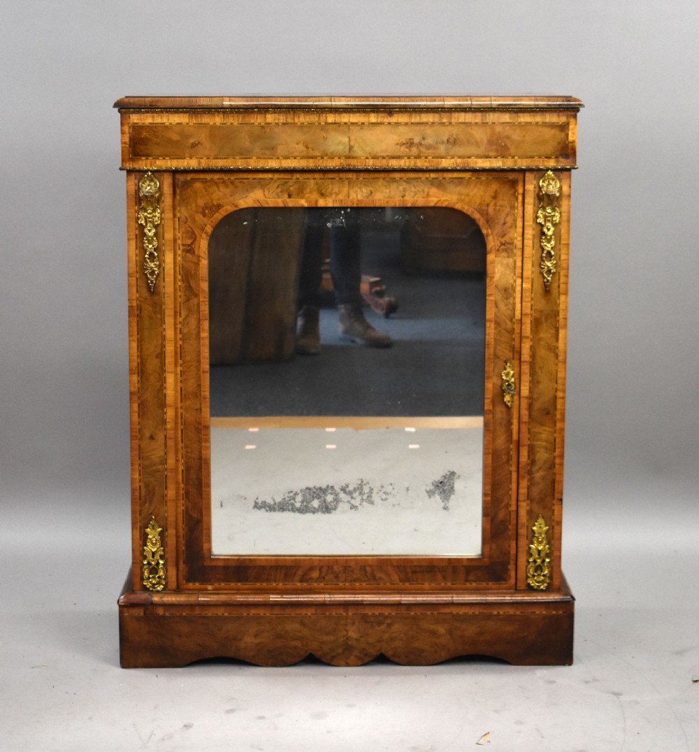 A Victorian burr walnut pier cabinet featuring a single glazed door, boxwood marquetry stringing, and ornate gilt brass mounts. View II