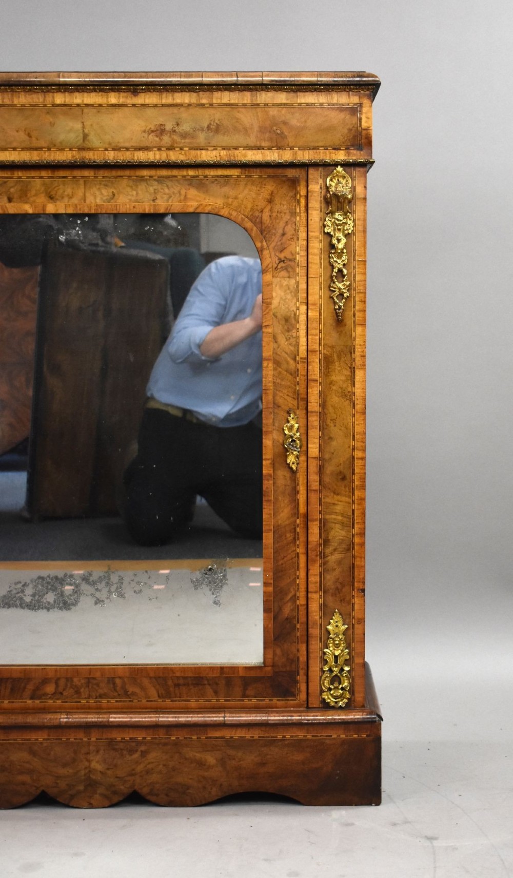 A Victorian burr walnut pier cabinet featuring a single glazed door, boxwood marquetry stringing, and ornate gilt brass mounts. View VIII