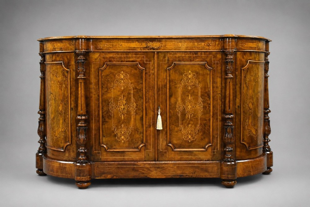 A Victorian burr walnut credenza featuring elaborate floral marquetry inlays on two central doors, flanked by turned columns and rounded side panels.