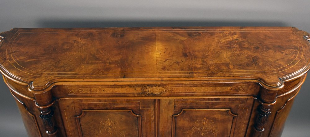 A Victorian burr walnut credenza featuring elaborate floral marquetry inlays on two central doors, flanked by turned columns and rounded side panels. View VII