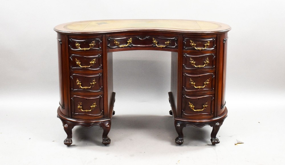 A dark mahogany kidney-shaped writing desk with a gilded leather top insert, twin pedestals featuring ornate brass handles, and cabriole legs ending in claw-and-ball feet. View II