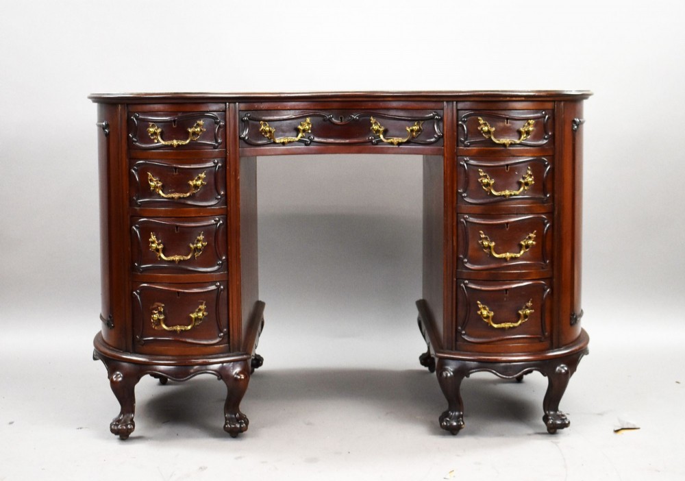 A dark mahogany kidney-shaped writing desk with a gilded leather top insert, twin pedestals featuring ornate brass handles, and cabriole legs ending in claw-and-ball feet. View III
