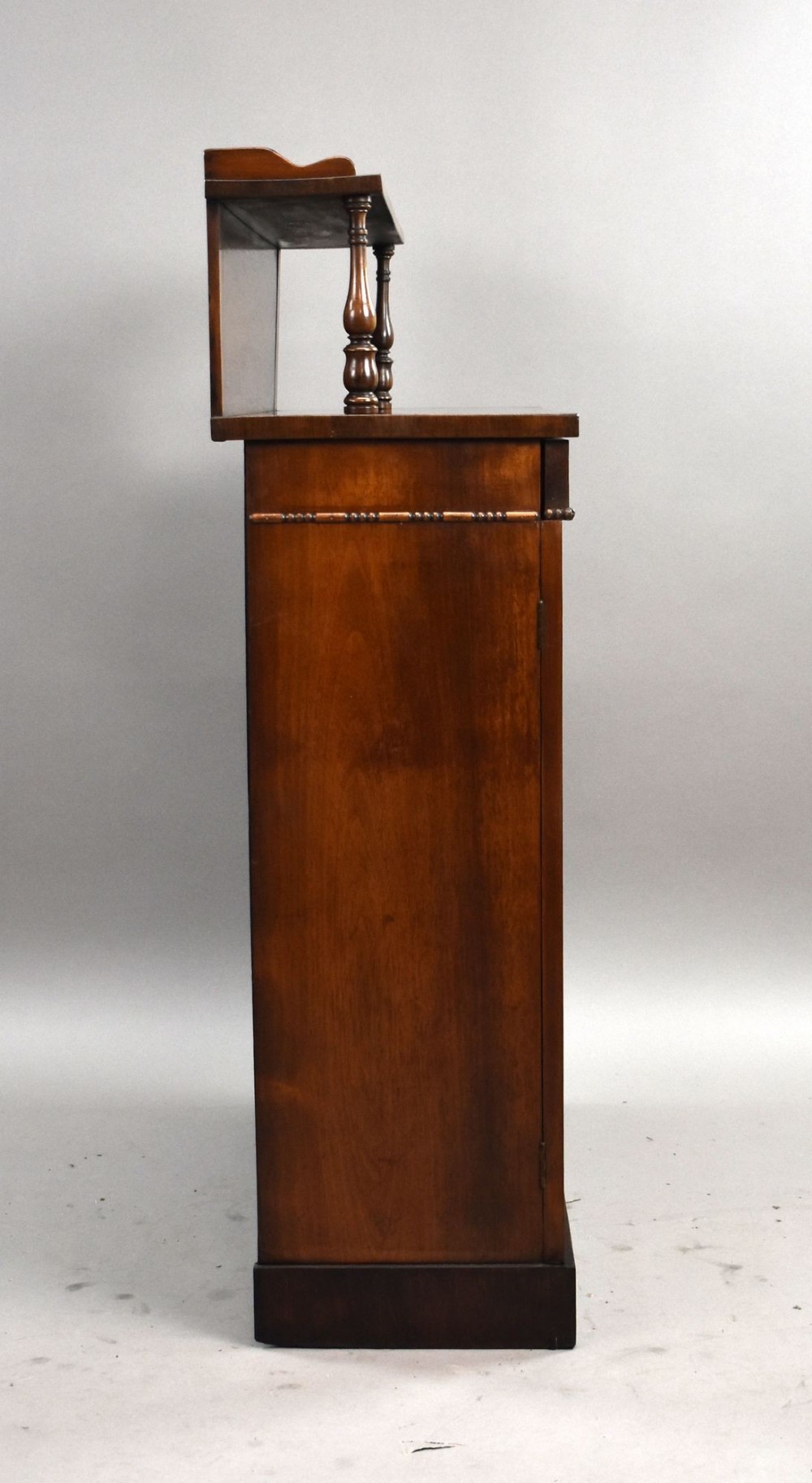 A Victorian dark rosewood chiffonier featuring an upper display shelf supported by turned pillars above lower cabinet doors fitted with pleated fabric panels. View III
