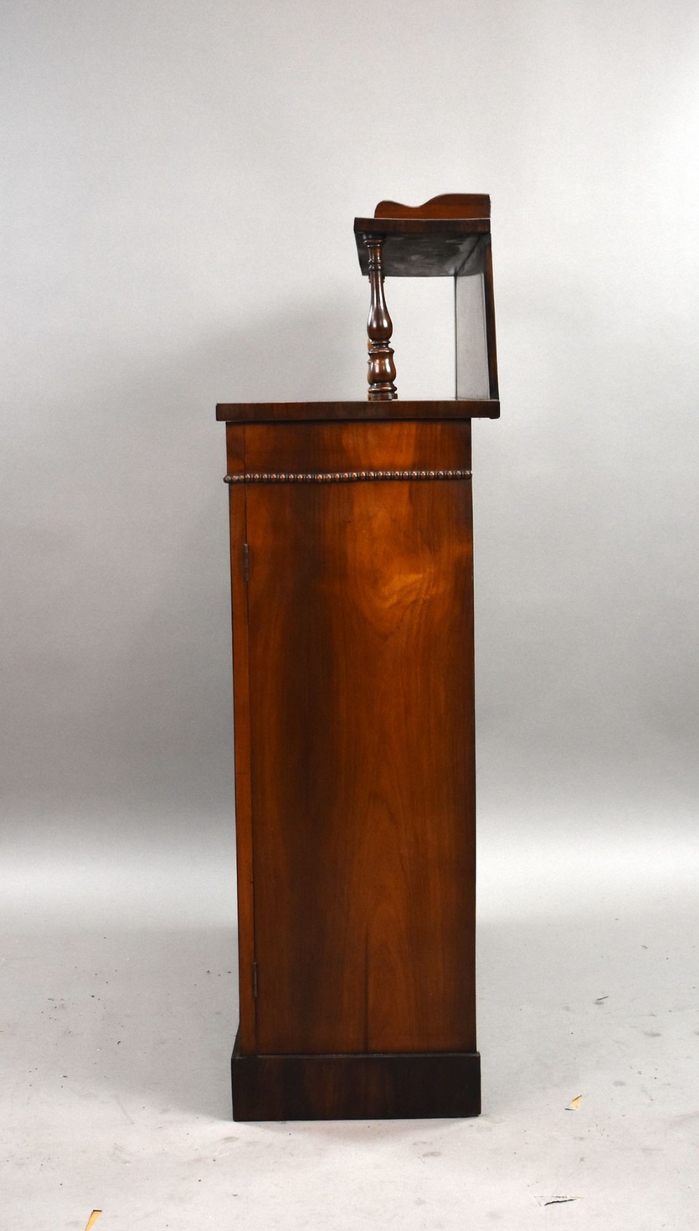 A Victorian dark rosewood chiffonier featuring an upper display shelf supported by turned pillars above lower cabinet doors fitted with pleated fabric panels. View IV