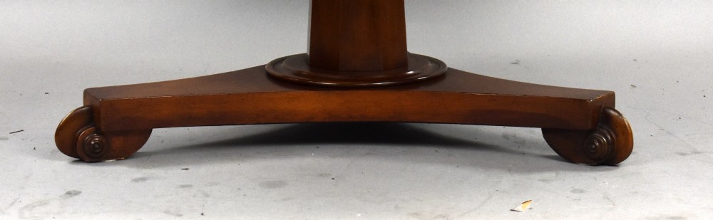 A low circular mahogany coffee table featuring a central pedestal stem on a tripartite platform base with scroll feet. View IV