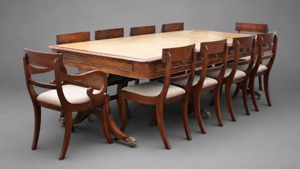 A large rectangular mahogany boardroom table with a leather inset top, accompanied by ten matching upholstered mahogany chairs resting on brass castor feet.