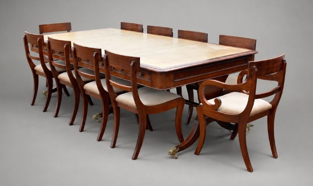 A large rectangular mahogany boardroom table with a leather inset top, accompanied by ten matching upholstered mahogany chairs resting on brass castor feet. View II