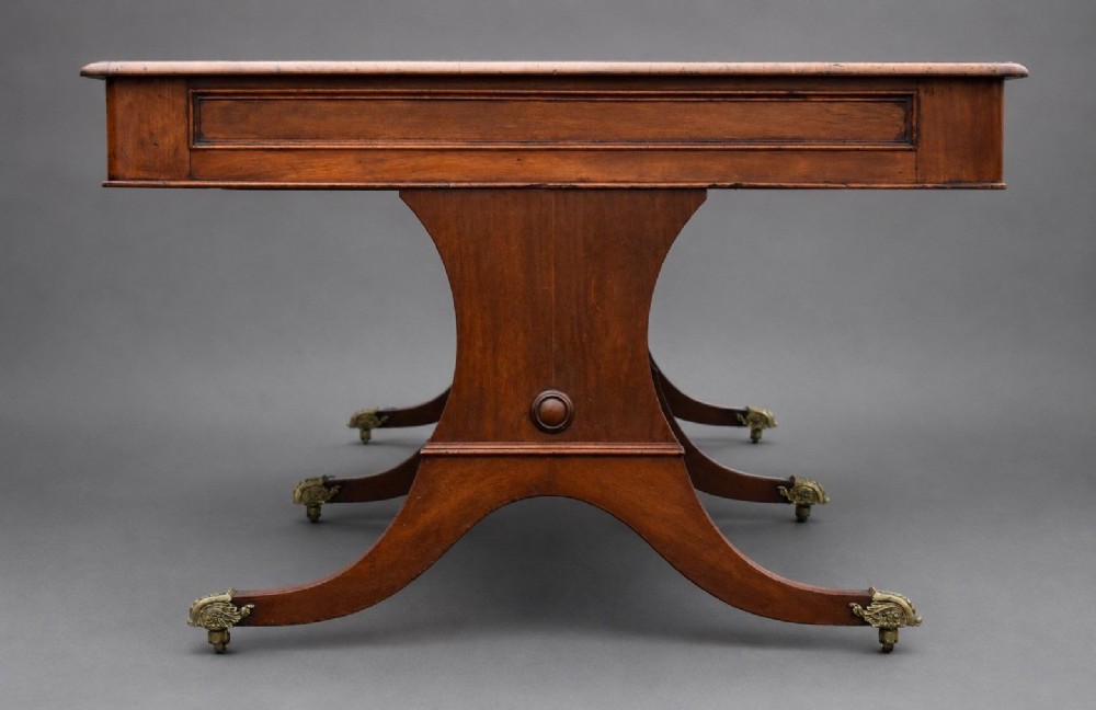 A large rectangular mahogany boardroom table with a leather inset top, accompanied by ten matching upholstered mahogany chairs resting on brass castor feet. View IV