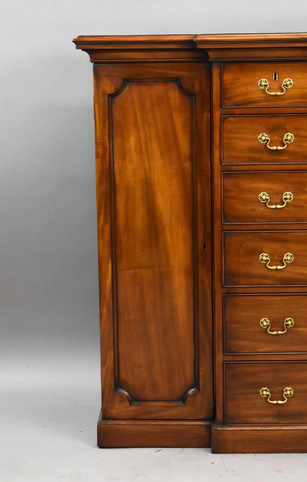 A Victorian mahogany breakfront sideboard featuring a central column of seven drawers flanked by two panelled cupboard doors with brass swan-neck handles. View II