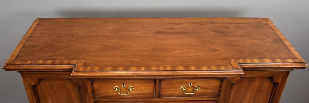 A Victorian mahogany breakfront sideboard featuring a central column of seven drawers flanked by two panelled cupboard doors with brass swan-neck handles. View VII