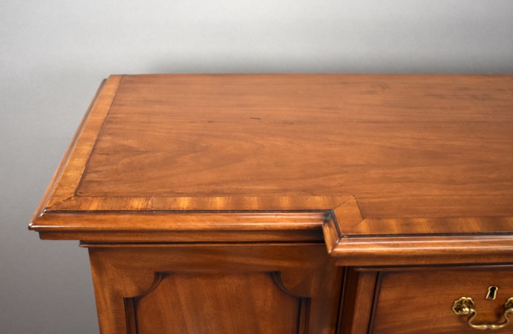 A Victorian mahogany breakfront sideboard featuring a central column of seven drawers flanked by two panelled cupboard doors with brass swan-neck handles. View VIII