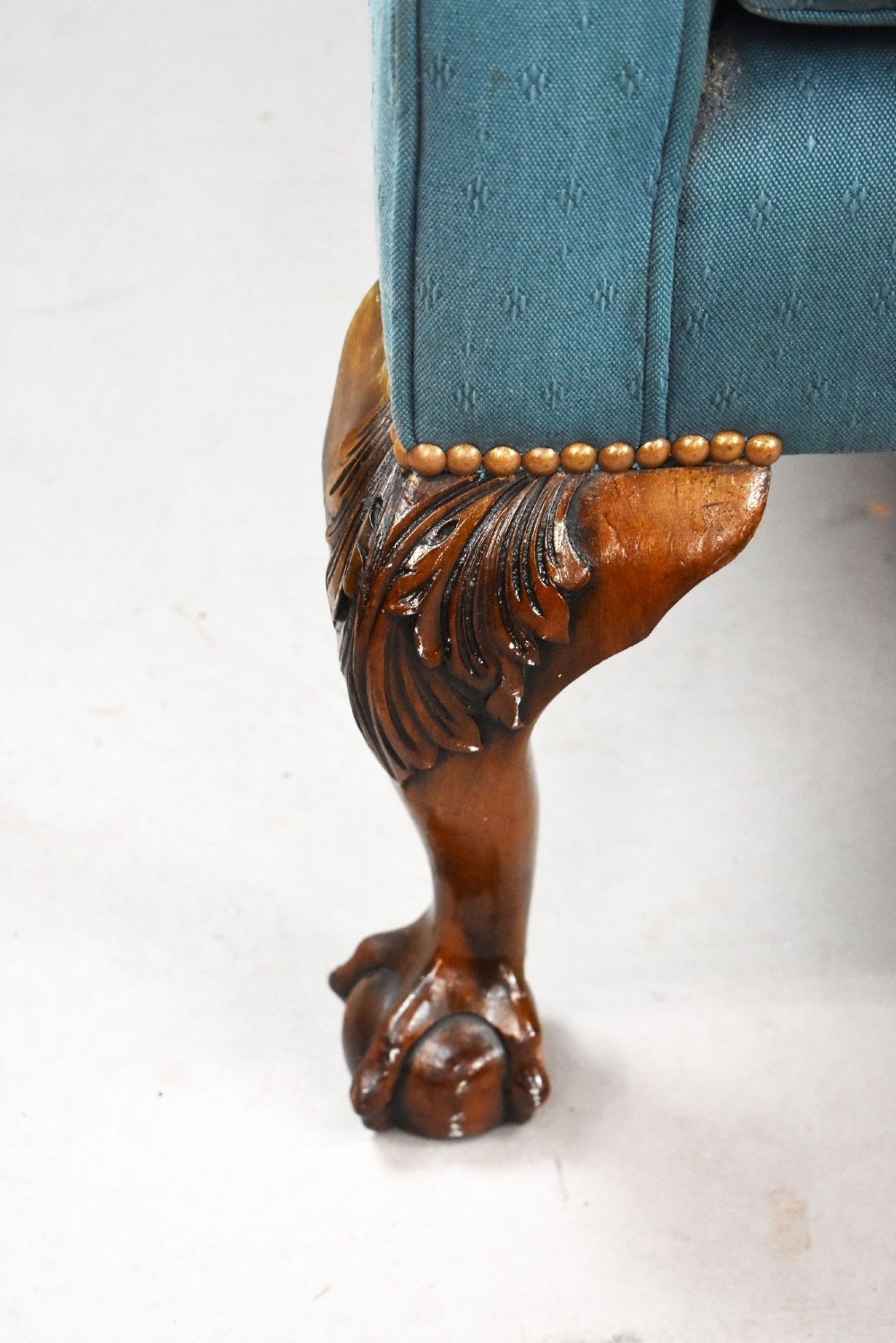 A pair of antique wingback armchairs upholstered in teal blue fabric with carved mahogany cabriole legs and claw-and-ball feet. View V