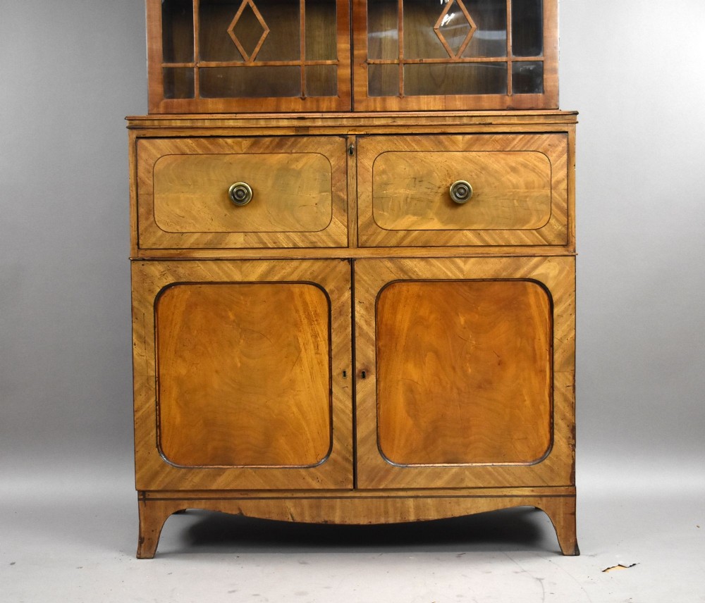 An antique mahogany secretaire bookcase featuring a glazed upper display cabinet with diamond astragal glazing bars above a lower chest and double cupboard base. View II