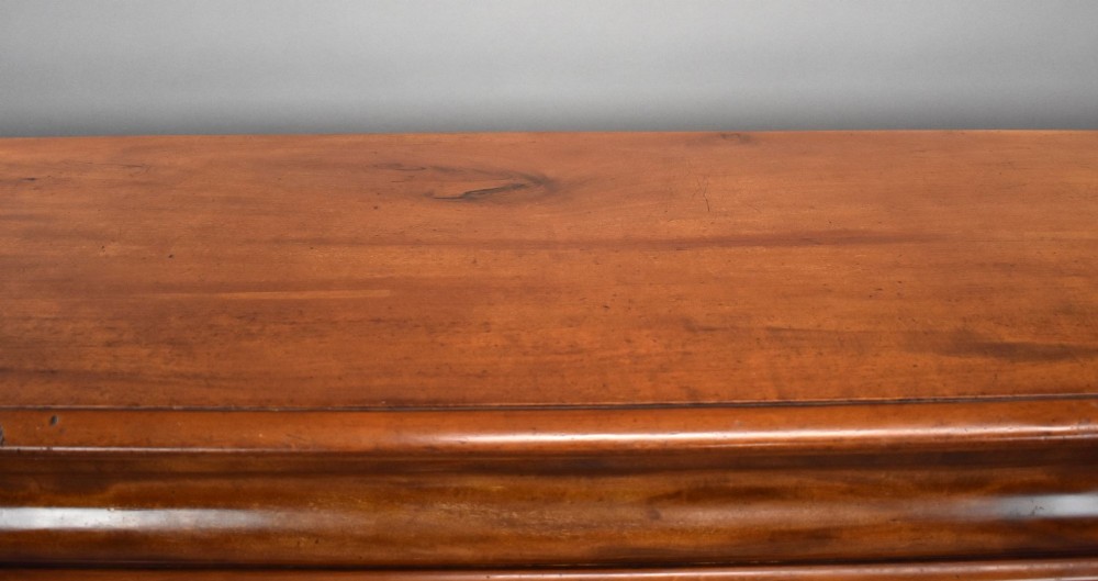 A nineteenth-century Victorian flame mahogany four-door sideboard featuring arched door panels, carved pilaster corbels, and a wide plinth base. View VI