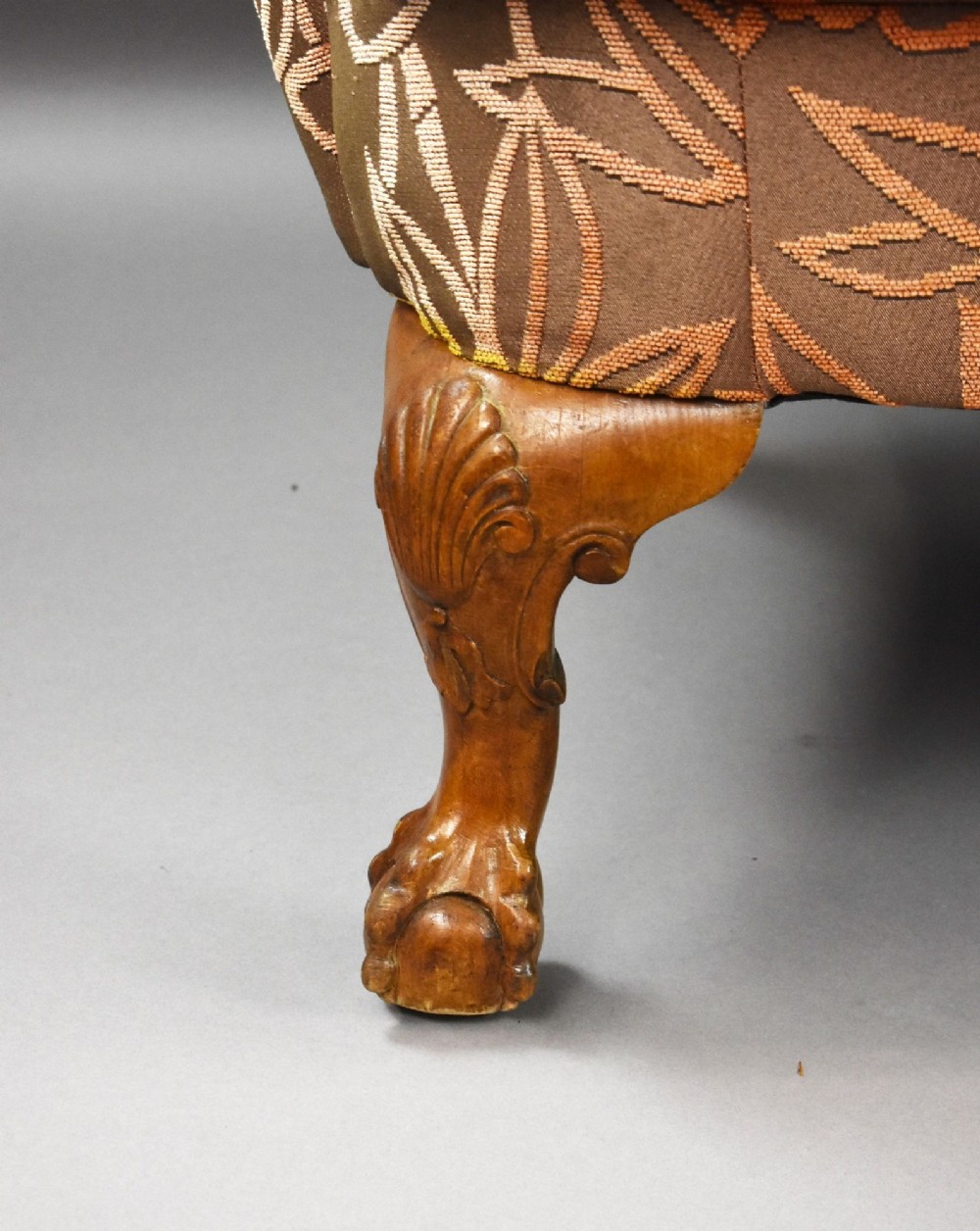 A Queen Anne style three-seat sofa featuring terracotta leaf-patterned upholstery, a triple-arched backrest, and carved walnut cabriole legs with ball-and-claw feet. View VI