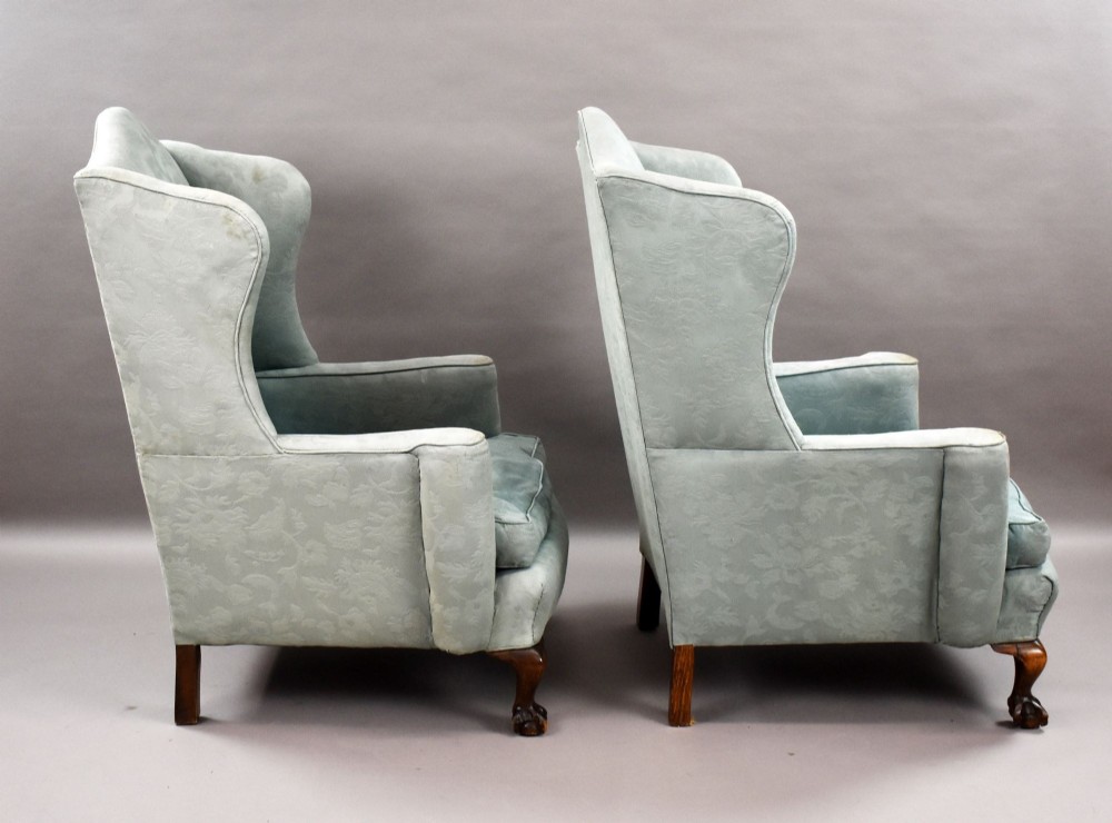A pair of antique wingback armchairs upholstered in duck egg blue damask fabric with carved cabriole legs and ball-and-claw feet. View V