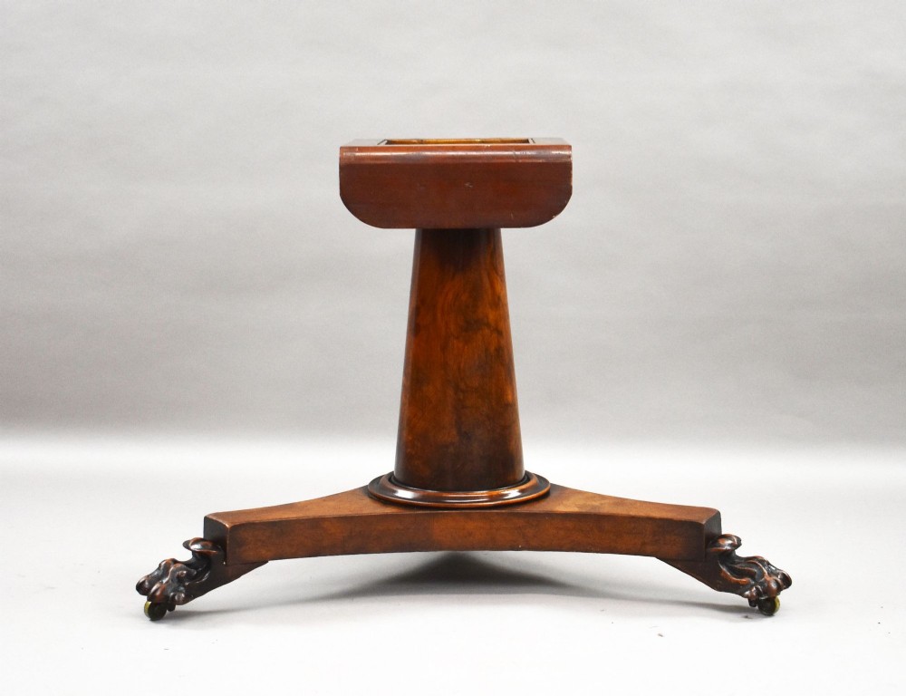 A circular Regency breakfast table with a figured burr elm veneered top displayed upright on a wooden pedestal base. View III