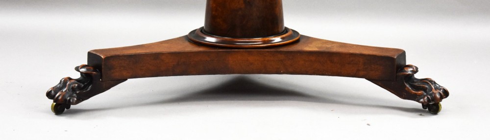 A circular Regency breakfast table with a figured burr elm veneered top displayed upright on a wooden pedestal base. View V