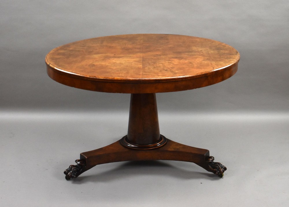 A circular Regency breakfast table with a figured burr elm veneered top displayed upright on a wooden pedestal base. View VII