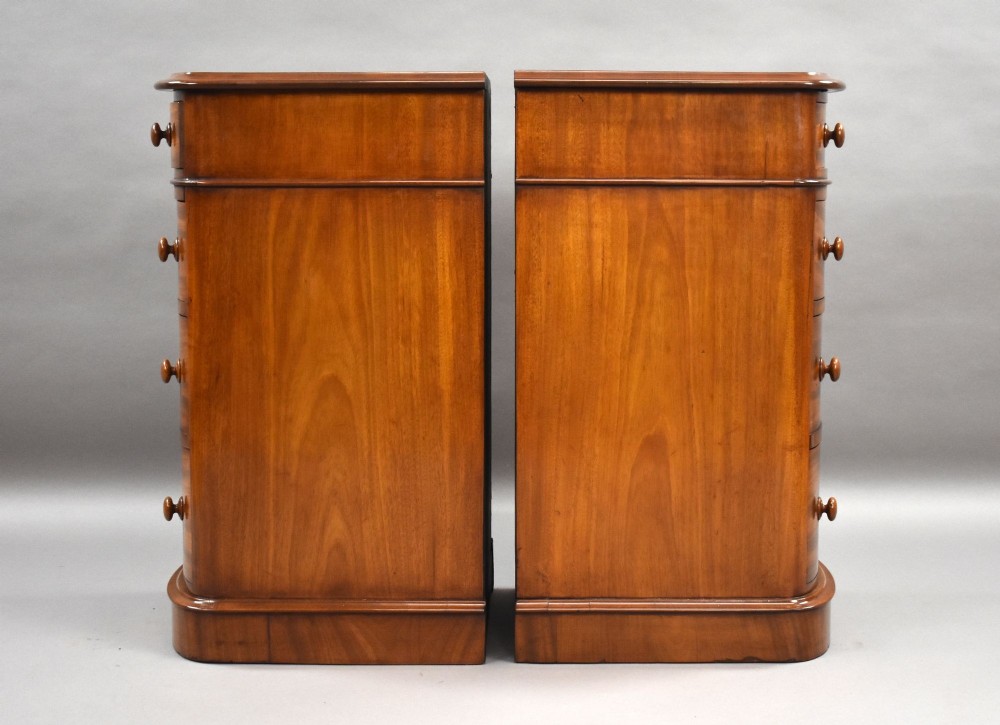 A matching pair of four-drawer Victorian mahogany bedside chests featuring curved fronted drawers, turned wooden handles, and plinth bases. View III