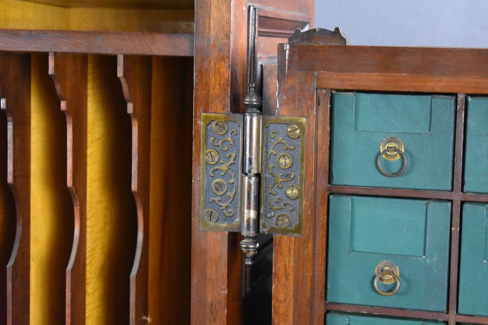 A Victorian walnut Wooton secretary desk featuring carved cresting, curved upper doors, panelling, brass mail slots, and carved feet on castors. View XII