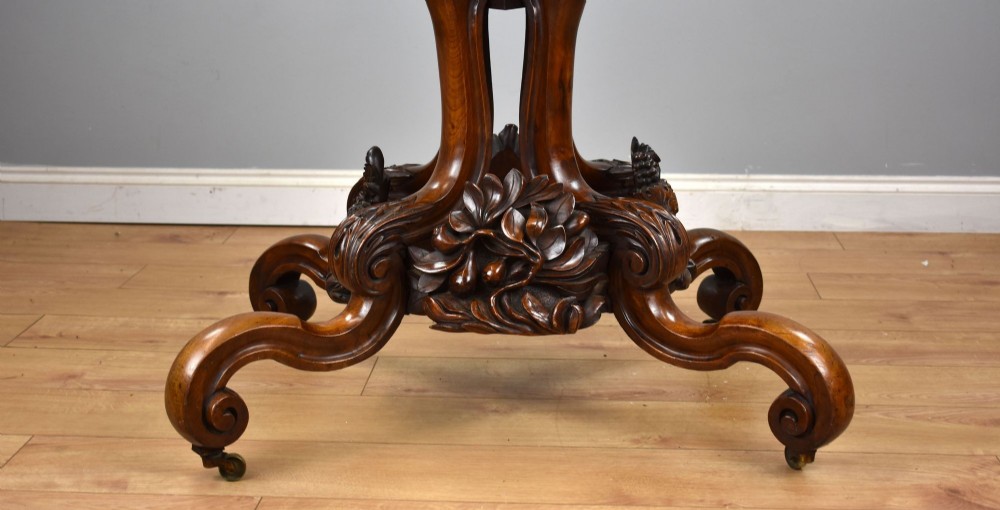 A Victorian tilt-top loo table shown vertically, featuring quarter-matched burr walnut veneer with a scalloped edge on carved cabriole legs. View VI