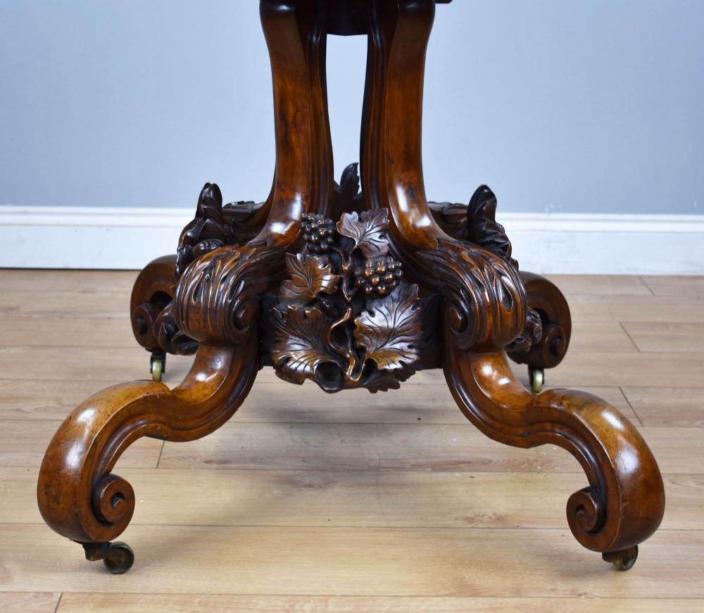 A Victorian tilt-top loo table shown vertically, featuring quarter-matched burr walnut veneer with a scalloped edge on carved cabriole legs. View IX