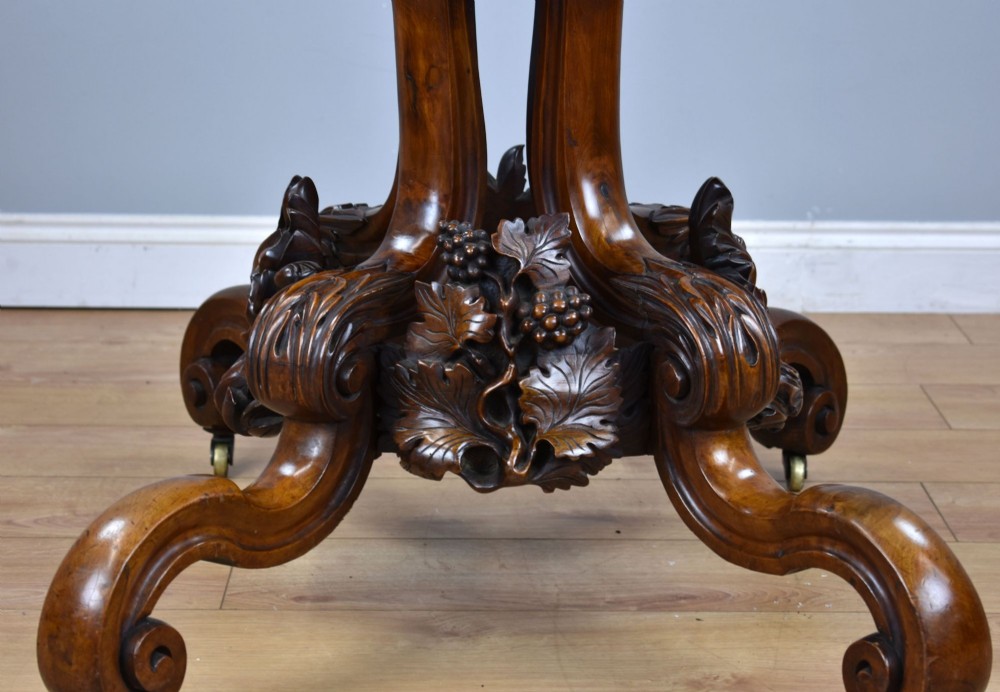 A Victorian tilt-top loo table shown vertically, featuring quarter-matched burr walnut veneer with a scalloped edge on carved cabriole legs. View X