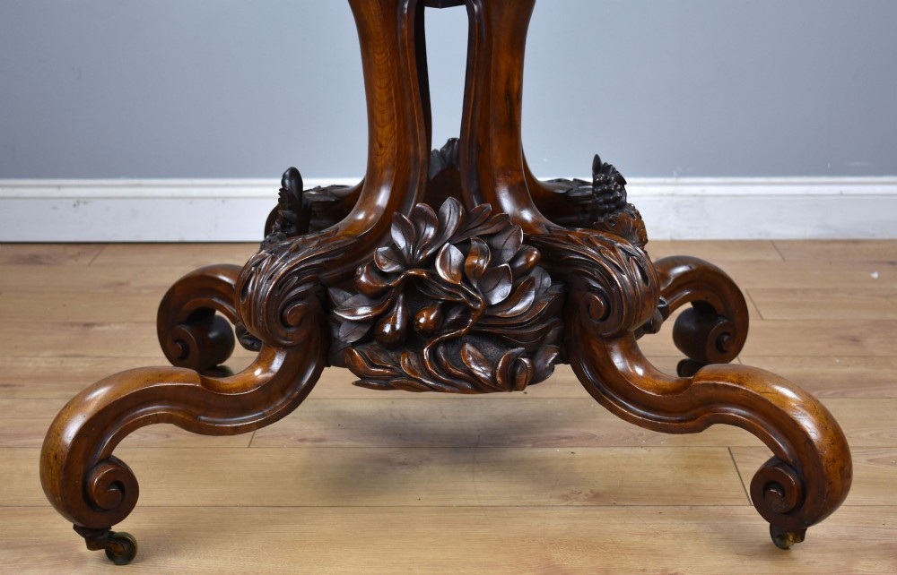 A Victorian tilt-top loo table shown vertically, featuring quarter-matched burr walnut veneer with a scalloped edge on carved cabriole legs. View XI