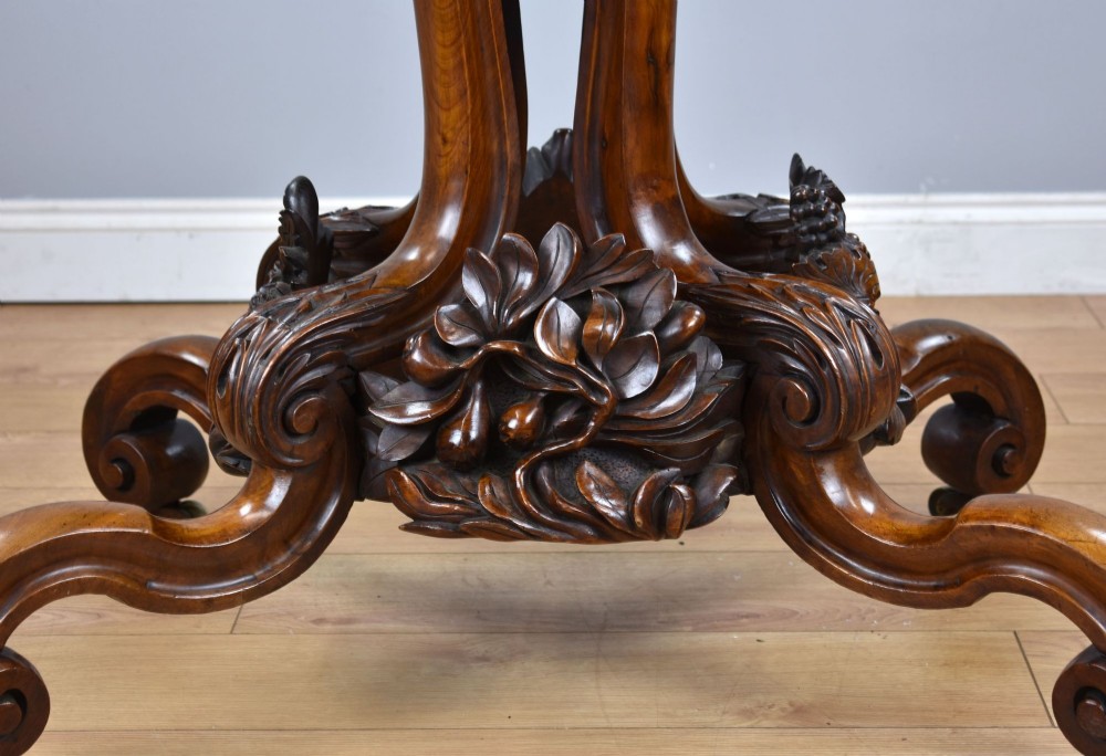 A Victorian tilt-top loo table shown vertically, featuring quarter-matched burr walnut veneer with a scalloped edge on carved cabriole legs. View XII