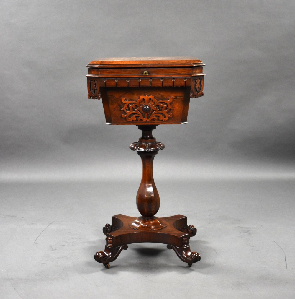 A William IV rosewood tea poy featuring a hinged lidded box top, carved openwork scrolls, a turned pedestal column, and a four-point base with scroll feet. View II