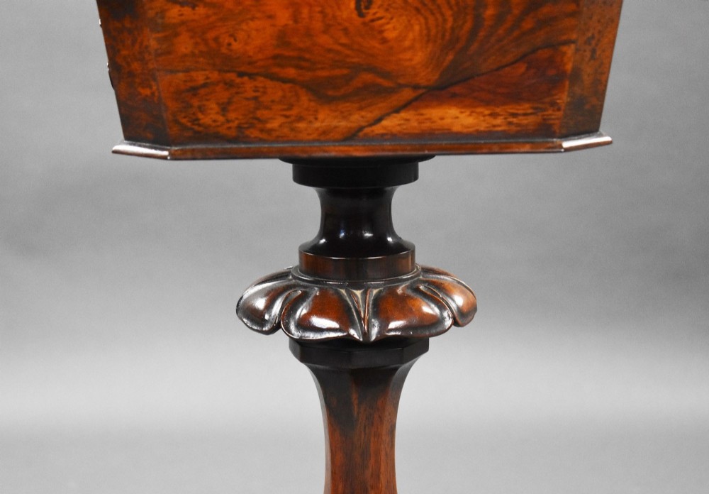 A William IV rosewood tea poy featuring a hinged lidded box top, carved openwork scrolls, a turned pedestal column, and a four-point base with scroll feet. View XIII