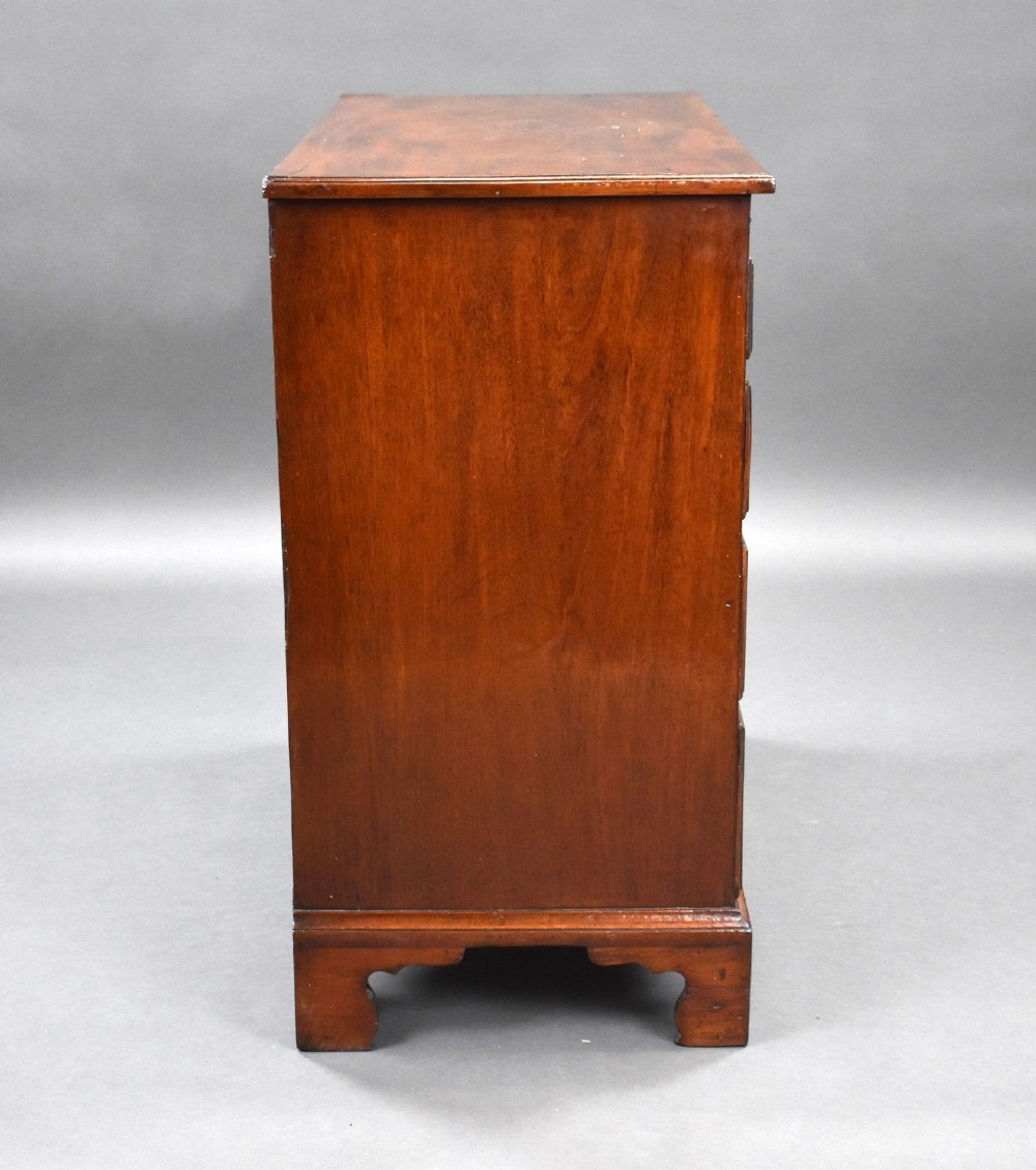 A George III mahogany bachelors chest of drawers featuring four graduated drawers, a pull-out brushing slide, brass swan-neck handles, and bracket feet. View III