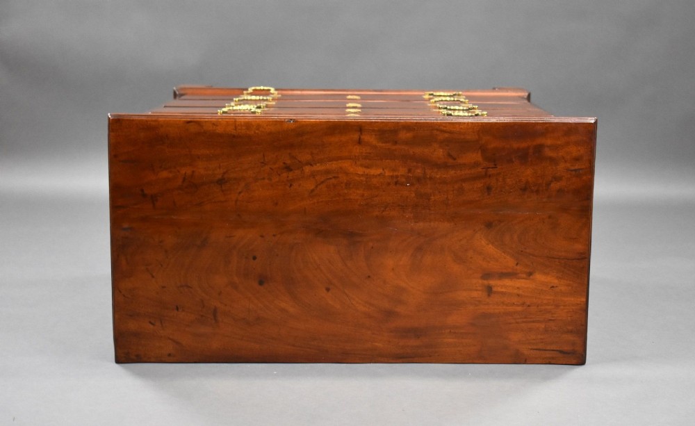 A George III mahogany bachelors chest of drawers featuring four graduated drawers, a pull-out brushing slide, brass swan-neck handles, and bracket feet. View V